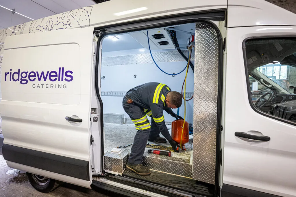Multimare technician servicing a Carrier refrigeration unit in a client's van.